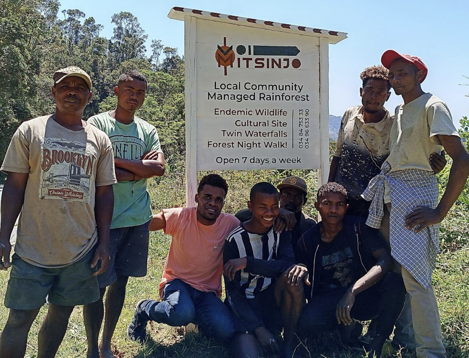 Members of VOI Mitsinjo beside the community-managed rainforest sign